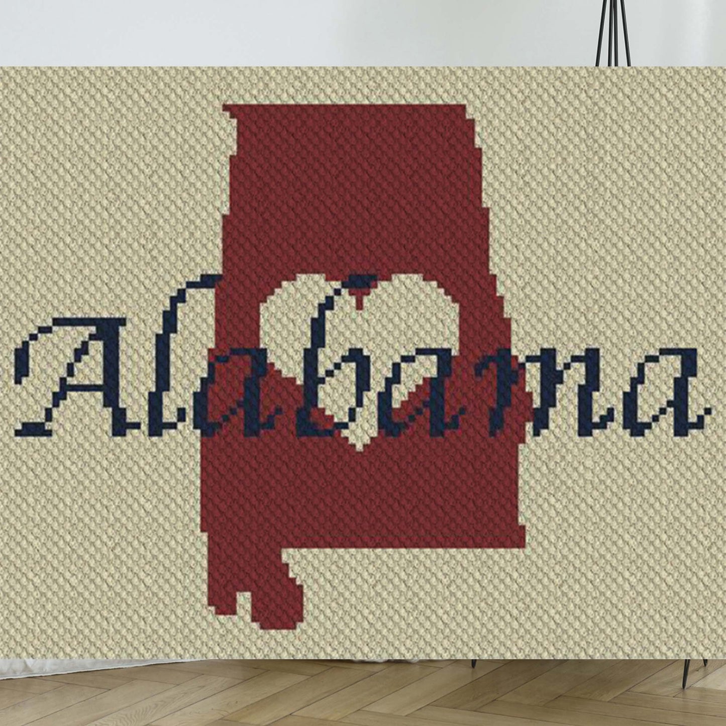 Pixel-art Alabama state outline with a centered heart in contrasting yarn colors