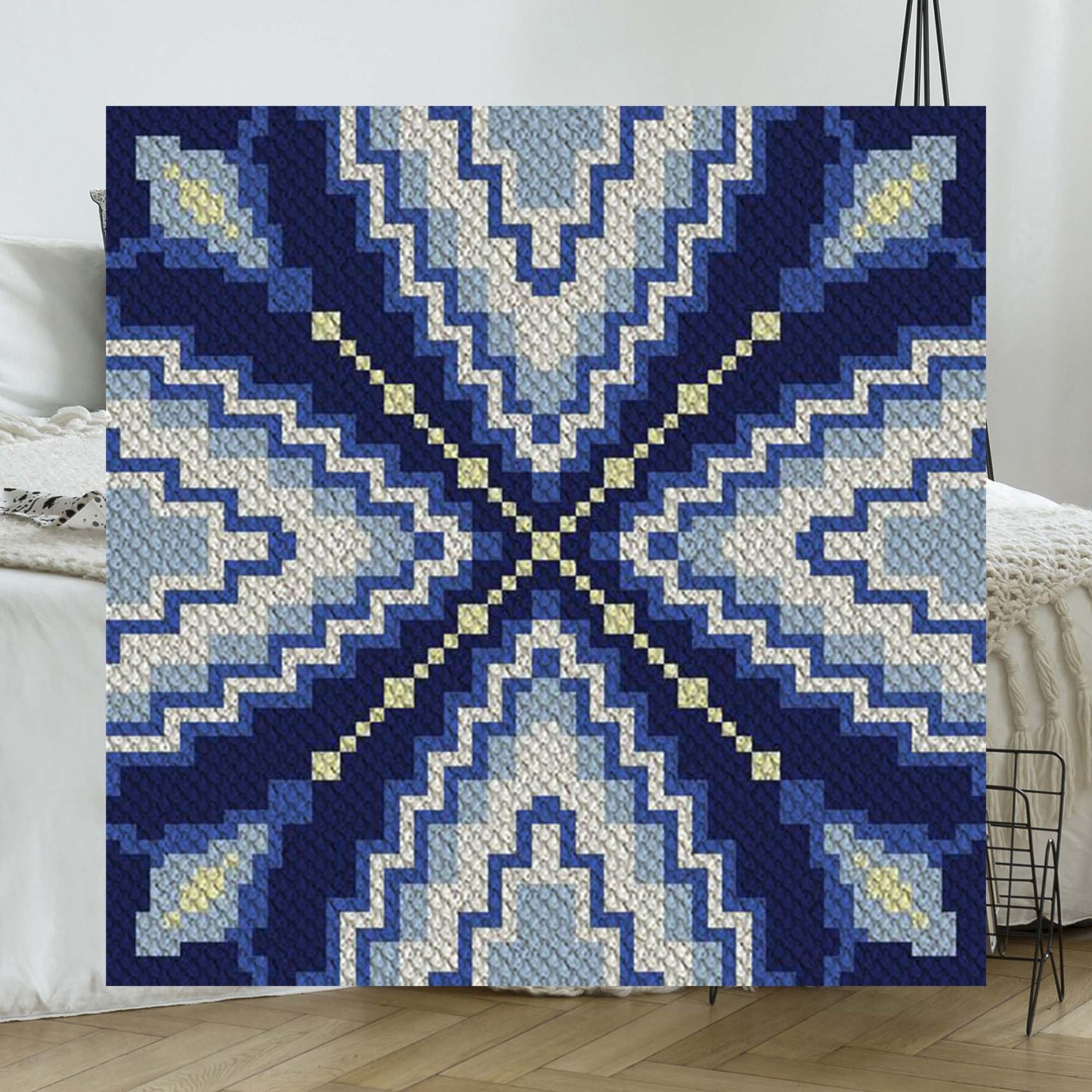 Concentric zigzag ripples in navy, cornflower, sky blue, and cream yarn blocks forming a water-reflection effect