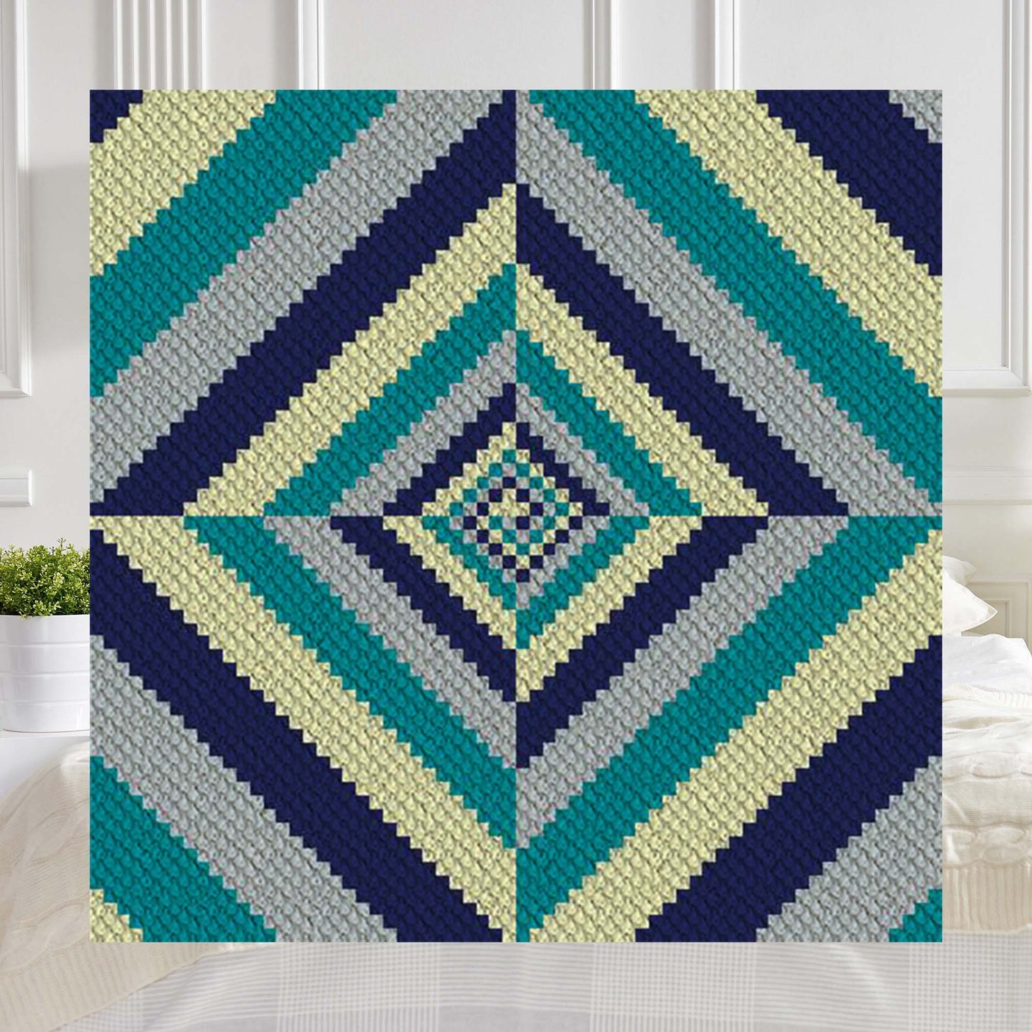Concentric diamond spirals in navy, teal, gray, and cream yarn blocks forming a vortex pattern