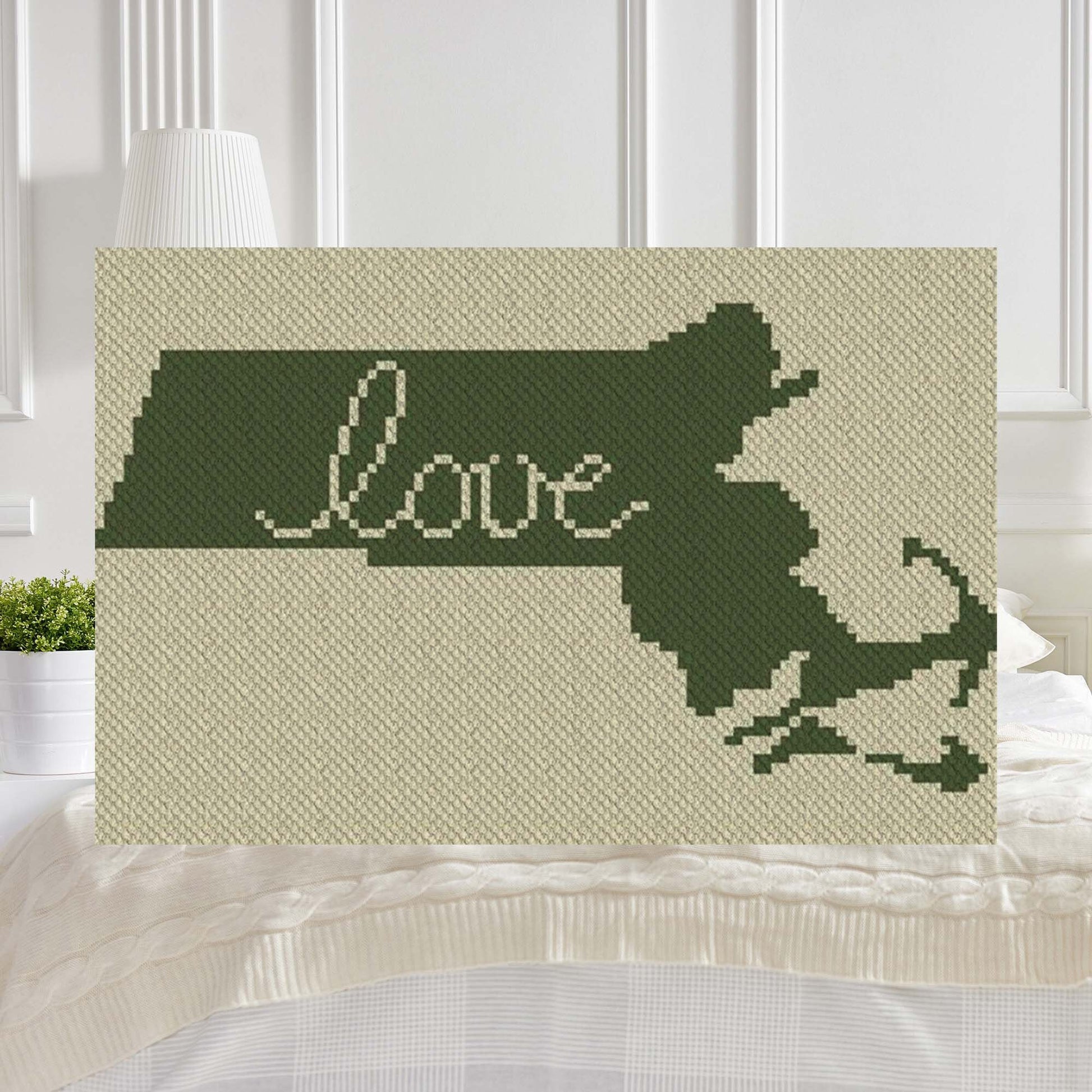Pixel-art Massachusetts outline with a heart motif in two contrasting yarn blocks