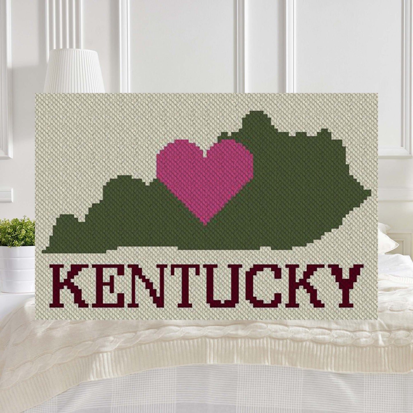 Pixel-art Kentucky shape with a centered heart in four contrasting yarn blocks