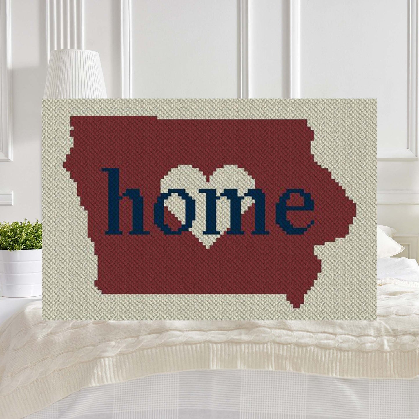 Pixel-art Iowa outline in three contrasting yarn blocks