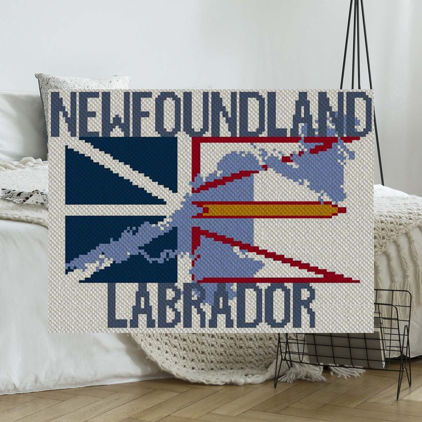 Twin-size afghan draped with the Newfoundland & Labrador flag in vibrant yarn colors
