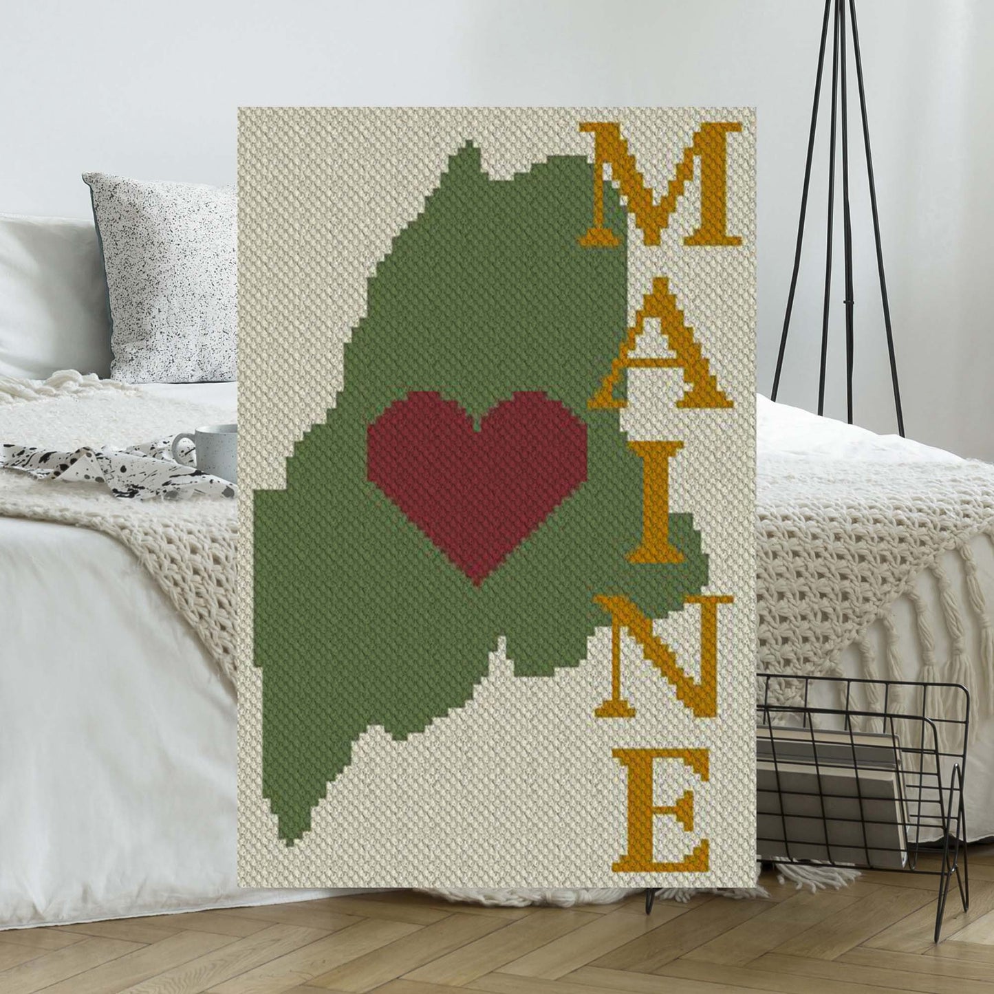 Pixel-art Maine silhouette with a bold heart in four vibrant yarn hues
