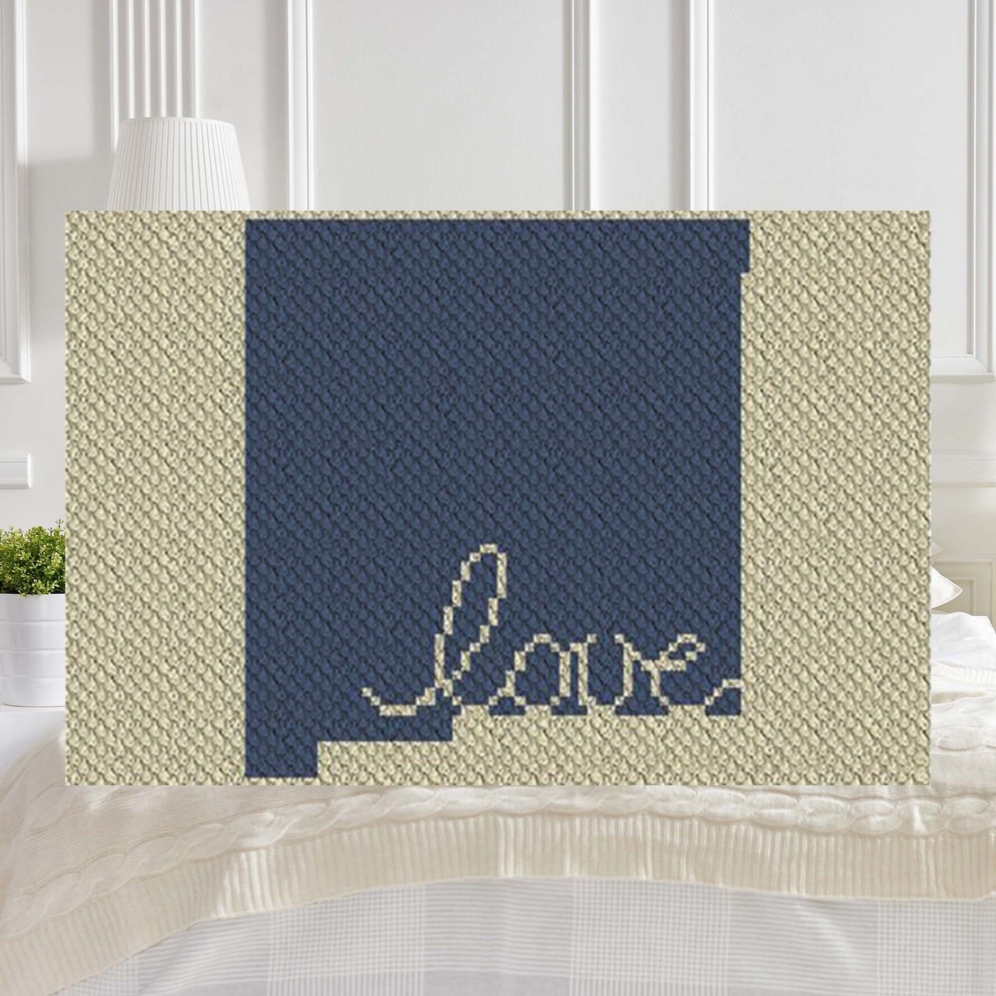 Pixel-art New Mexico outline with heart motif in two contrasting yarn blocks