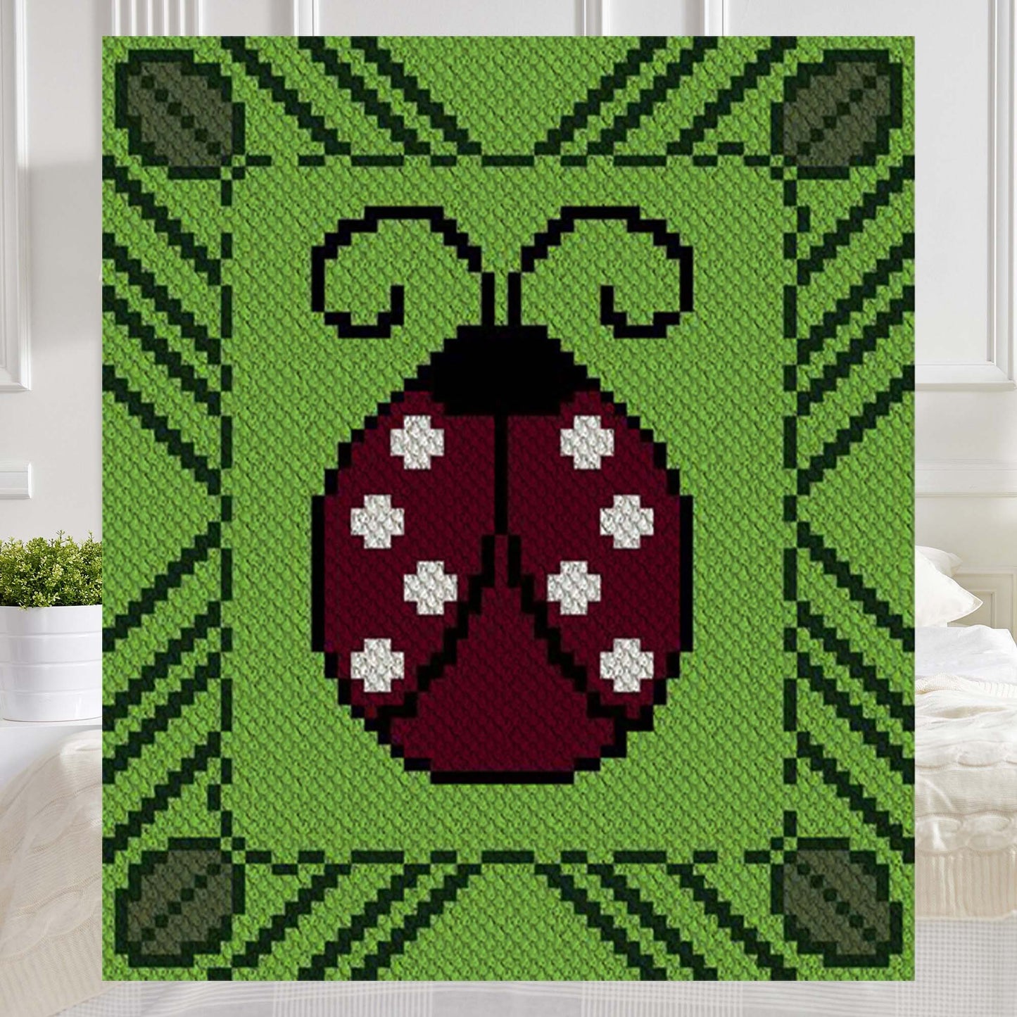 Ladybug with white spots centered in a green leafy border, pixelated for C2C